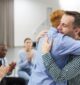 Men hugging in group therapy in Massachusetts.