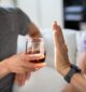 person putting their hand up to refuse a drink after quitting alcohol