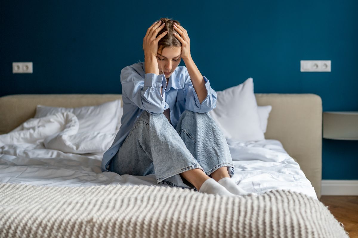 woman sitting in bed experiences trauma in her hips