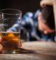 man with alcohol brain fog with head down holding a beer