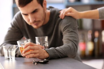 person drinking too much alcohol gets support from friend